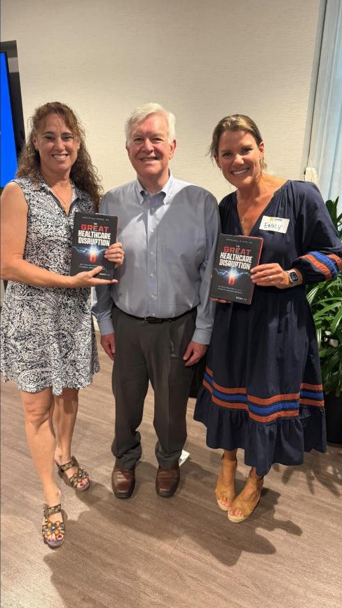 Dr. Marschall Runge with attendees holding The Great Healthcare Disruption at the University of Michigan Club of Greater Chicago